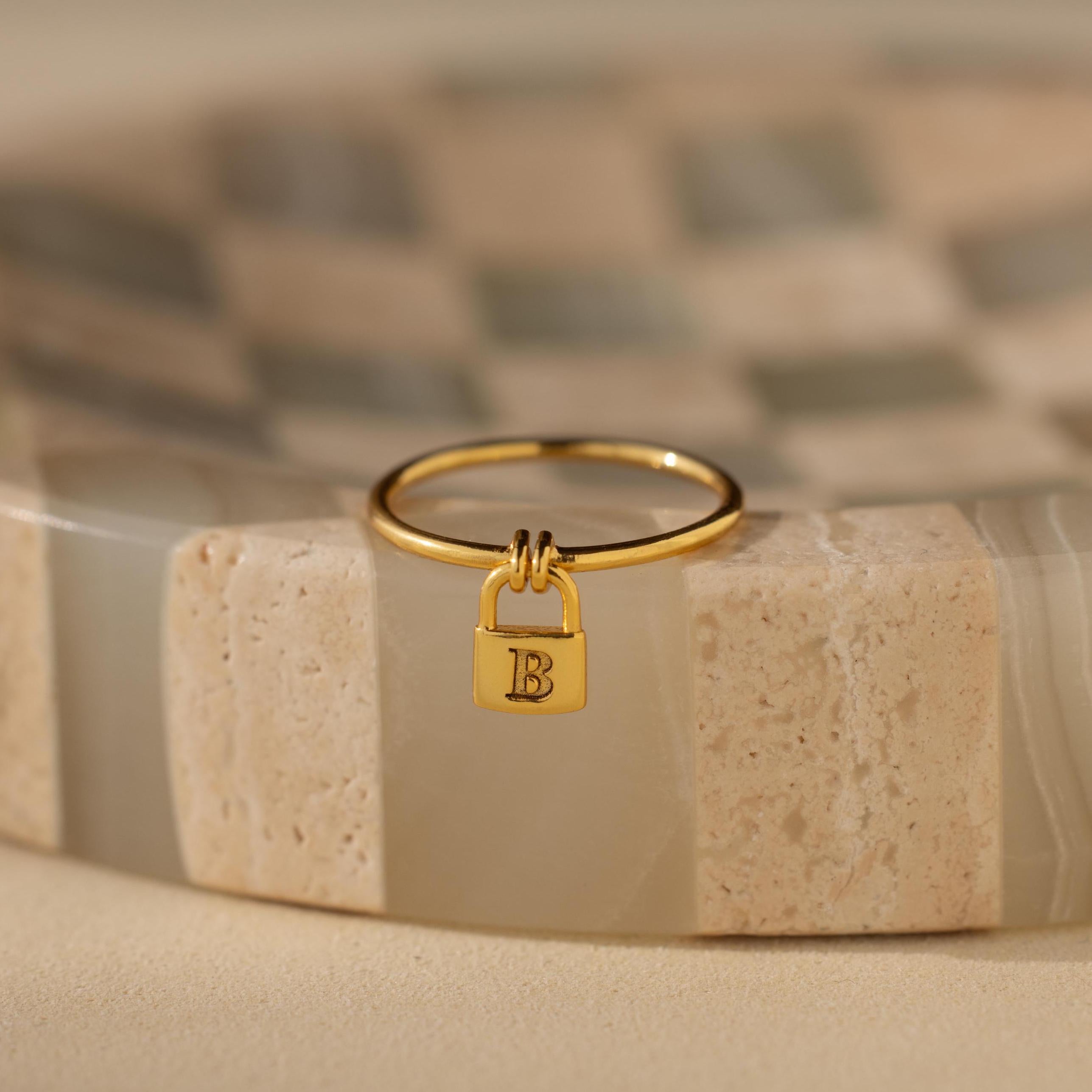 Gold initial ring featuring a mini padlock design.